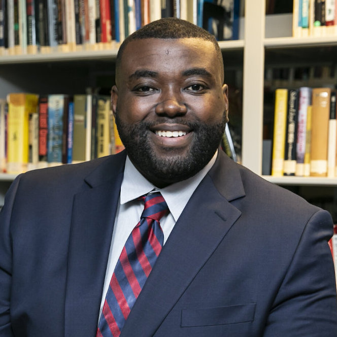 headshot of Dr. Charles Chavis, in front of a bookshelf